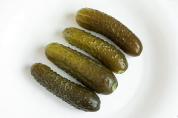 Pickle cucumbers on white plate top view. Fermented vegetables. 