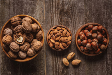 top view of nuts in bowls arranged on wooden tabletop