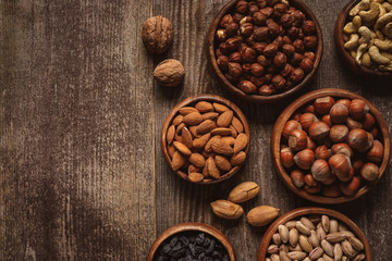 top view of nuts in bowls arranged on wooden tabletop