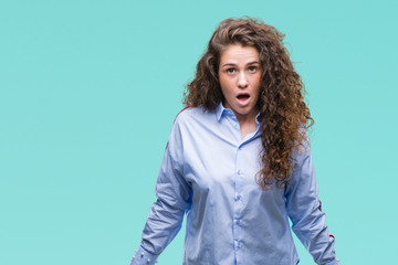Obraz premium Beautiful brunette curly hair young girl wearing elgant look over isolated background afraid and shocked with surprise expression, fear and excited face.