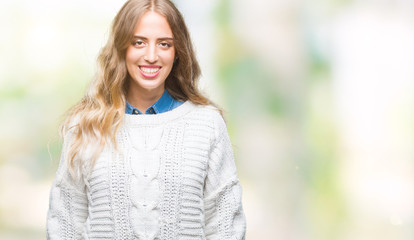 Beautiful young blonde woman wearing winter sweater over isolated background with a happy and cool smile on face. Lucky person.