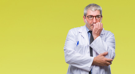 Handsome senior doctor, scientist professional man wearing white coat over isolated background looking stressed and nervous with hands on mouth biting nails. Anxiety problem.