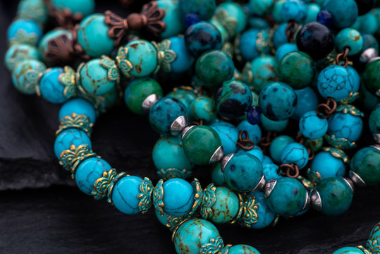 Bracelets made of natural stones on a dark background. Azurmalahite, turquoise, lapis lazuli.