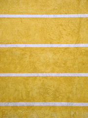Painted plaster yellow wall of the building with white stripes