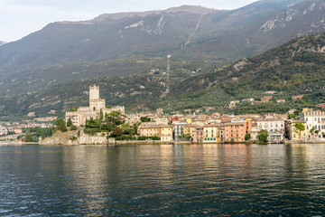 Fototapeta na wymiar view of the old town of malcesine, in the background the monte baldo with cable car station 