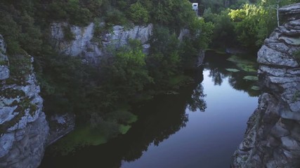 Aerial shot of snaky creek flowing between steep rocks in Carpathians in summer