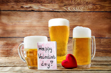 Glass of cold light beer with heart on a wood background for Valentine's day