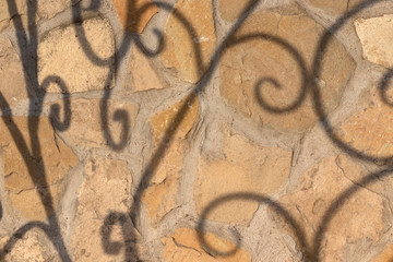 Natural stone laid out on a plane and attached to cement with glue with shadows from the grid