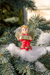 Winter angel figure red new year in the snow on the Christmas tree concept