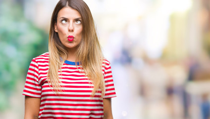 Young beautiful woman casual look over isolated background making fish face with lips, crazy and comical gesture. Funny expression.