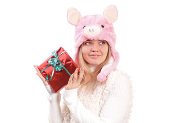 girl in a pig hat, a symbol of the new year, holds a gift, dreams