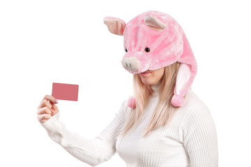 Obraz premium girl in pig hat, holding business card in her hands, isolated on white background