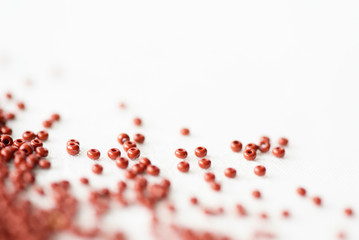 Brown seed beads scattered on textile background close up