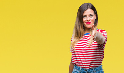 Young beautiful woman casual look over isolated background smiling friendly offering handshake as greeting and welcoming. Successful business.