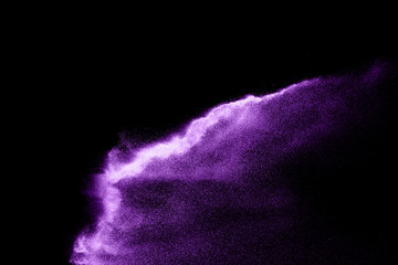 Purple sand explosion isolated on black background. Abstract sand cloud.Purple sand splash against ...