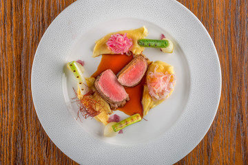 delicious pork fillet with potatoes mash and vegetables served on white plate with sauce, product photography  for restaurant