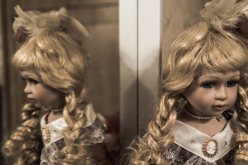 Old porcelain doll girl with blonde hair in vintage dress - 238748221