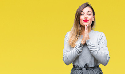 Young beautiful worker business woman over isolated background praying with hands together asking for forgiveness smiling confident.