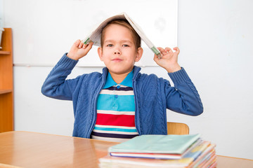 the boy puts the book on his head
