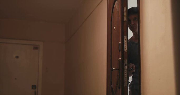 young man picks up the bag and quickly closes the door