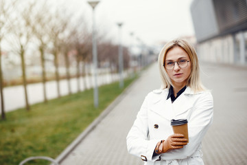Fototapeta premium Young stylish pretty woman posing in the city streets and using 