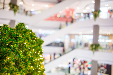Green christmas tree with blurry department store