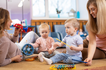 Musical education for preschoolers. Parents play musical toys with their children
