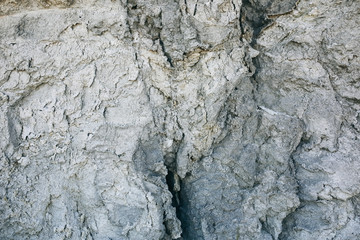 Chapped desert ground texture. White grey sand with stone background.