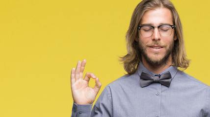 Young handsome man with long hair wearing bow tie over isolated background relax and smiling with...