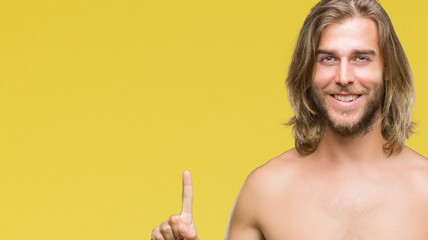 Young handsome shirtless man with long hair showing sexy body over isolated background showing and pointing up with finger number one while smiling confident and happy.