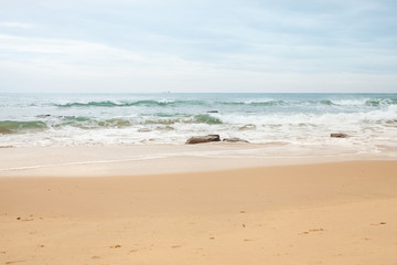 Fototapeta na wymiar Boulders on the sandy beach by the sea