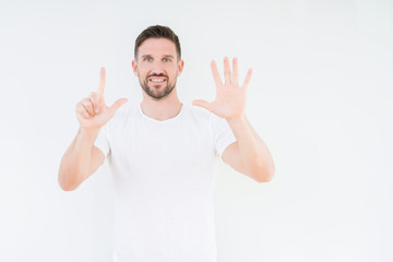 Naklejka premium Young handsome man wearing casual white t-shirt over isolated background showing and pointing up with fingers number seven while smiling confident and happy.