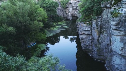 Mountain streamlet stretching at a sharp rocky wall in the Carpathians in summer