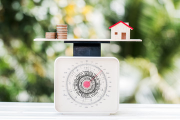 Home money coins on balance Weighing Scales on wood green background. Concept of saving buy new...