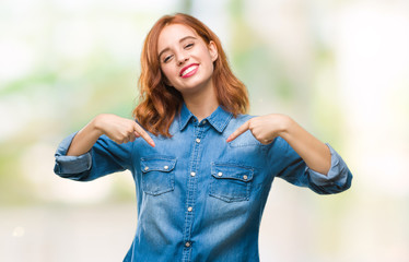 Young beautiful woman over isolated background looking confident with smile on face, pointing...