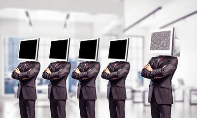 Businessmen with monitors instead of head.