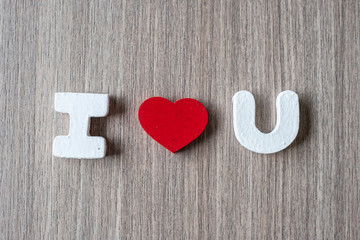 I Love U word of wooden alphabet letters with red heart shape on table background. Romance, Romantic and Valentine’s day concepts