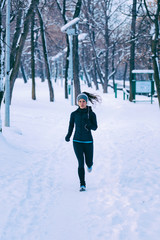Female athlete jogging in park in winter