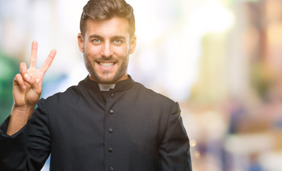 Naklejka premium Young catholic christian priest man over isolated background showing and pointing up with fingers number two while smiling confident and happy.