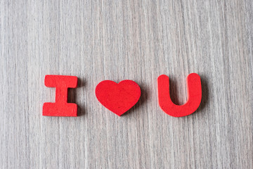 I Love U word of wooden alphabet letters with red heart shape on table background. Romance, Romantic and Valentine’s day concepts
