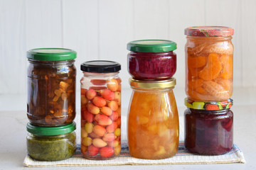 Fototapeta na wymiar Variety of preserved food in glass jars - pickles, jam, marmalade, sauces, ketchup. Preserving vegetables and fruits. Fermented food. Autumn canning. Conservation of harvest