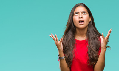 Young beautiful arab woman over isolated background crazy and mad shouting and yelling with...