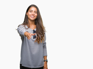 Young beautiful arab woman wearing sunglasses over isolated background smiling friendly offering handshake as greeting and welcoming. Successful business.