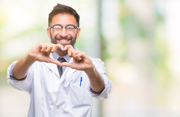 Adult hispanic scientist or doctor man wearing white coat over isolated background smiling in love showing heart symbol and shape with hands. Romantic concept.