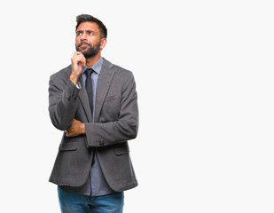 Fototapeta premium Adult hispanic business man over isolated background with hand on chin thinking about question, pensive expression. Smiling with thoughtful face. Doubt concept.