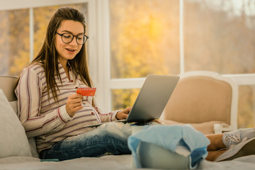 Pregnant woman doing online shopping with bonus card