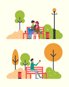 Couple Sitting in Autumn Park on Bench with Notebook