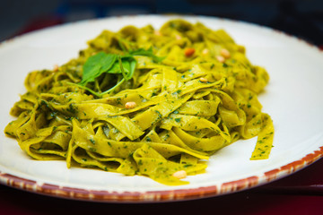 Pasta with pesto sauce and nuts on a the table