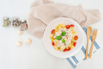 Cooked pasta with a cream sauce and roasted chicken cured with emmental.