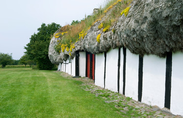 Laesoe / Denmark: View along the exterior wall of an old half-timbered farmhouse thatched with a seaweed roof
